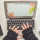Woman in fingerless gloves typing