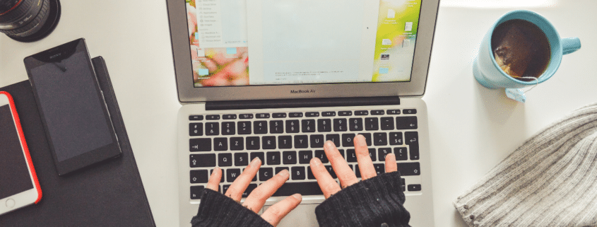 Woman in fingerless gloves typing