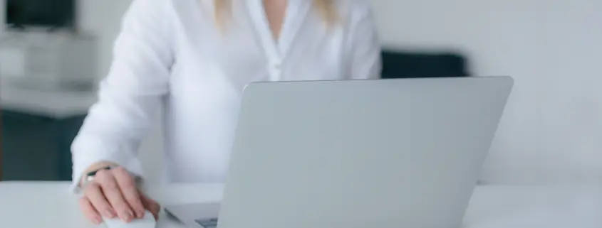 woman at laptop computer with phone